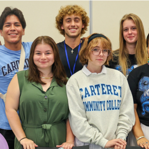 A group of smiling Carteret CC students pose together at an event.