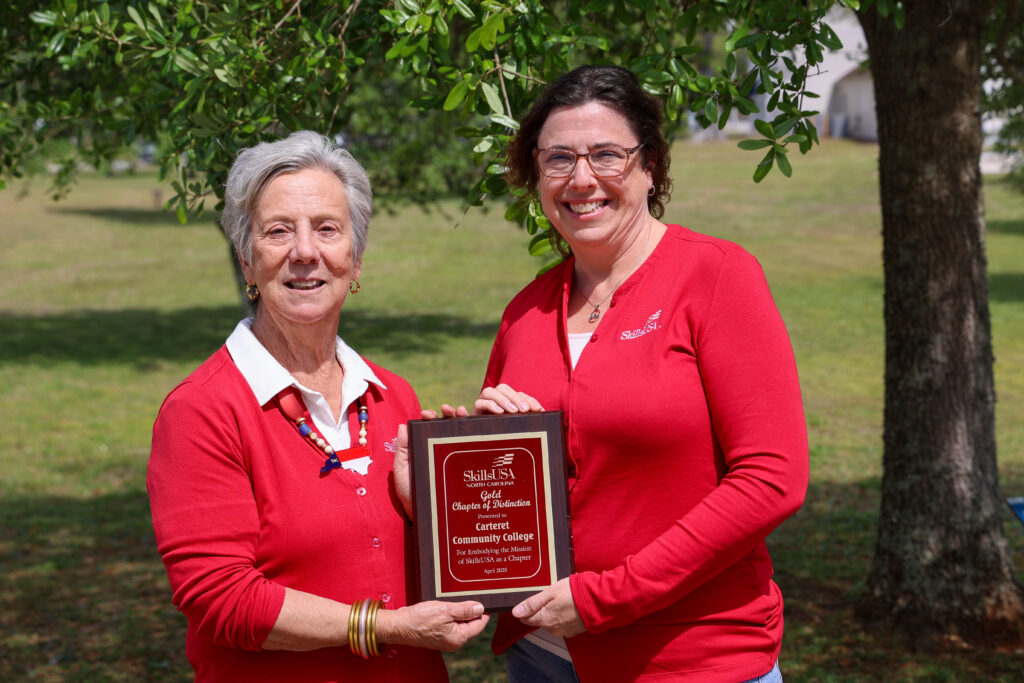 Two ladies standing side by side holding a plaque for SkillsUSA.