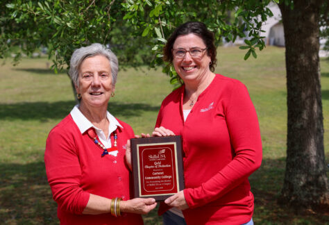 Two ladies standing side by side holding a plaque for SkillsUSA.