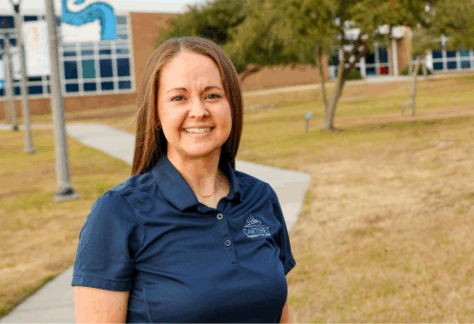 A female outside in a blue shirt with a carteret logo
