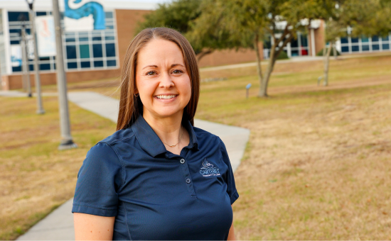 A female outside in a blue shirt with a carteret logo