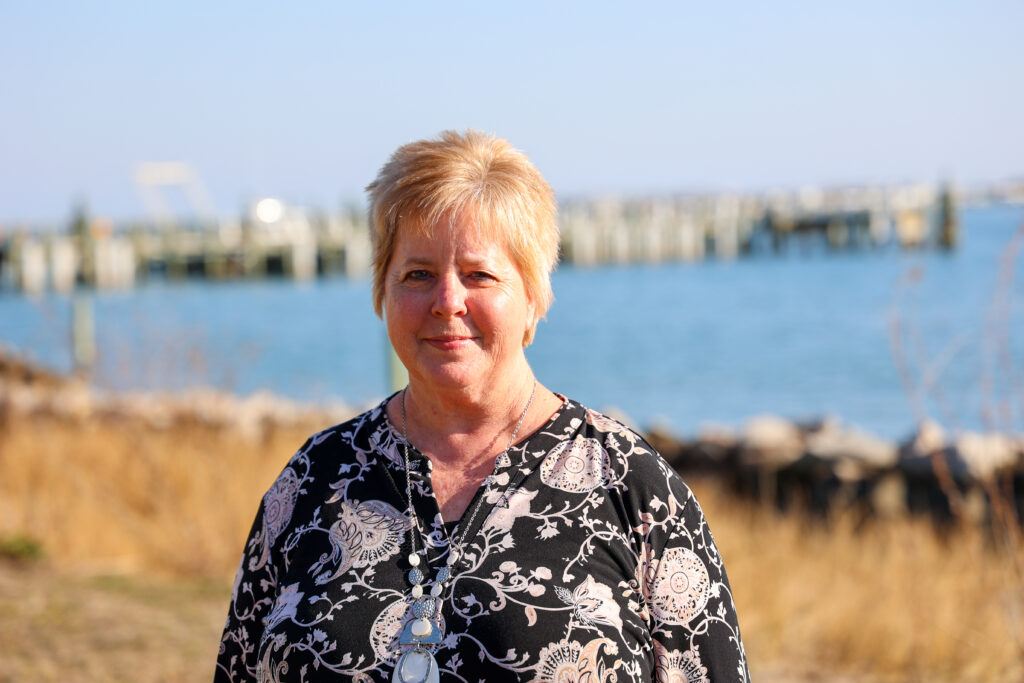 a picture of a women outside by the water