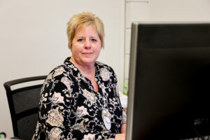 A women sitting at her desk in front of a computer.