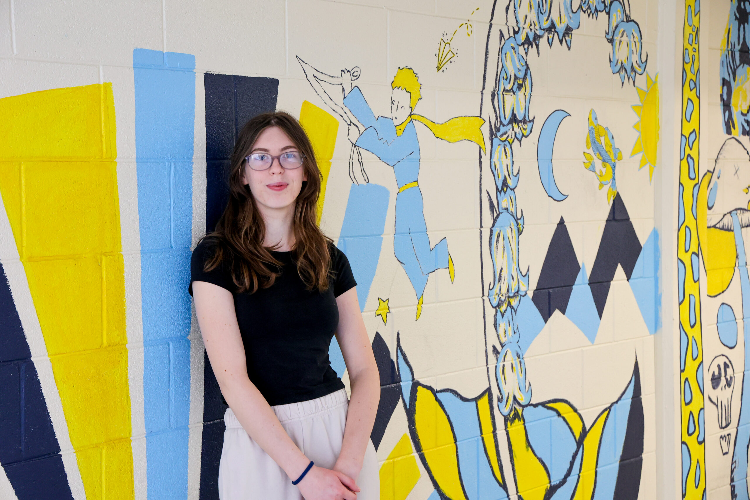 Emily Simons, a senior at East Carteret High School, stands in front of a colorful school mural while participating in Carteret Community College’s College and Career Promise program.