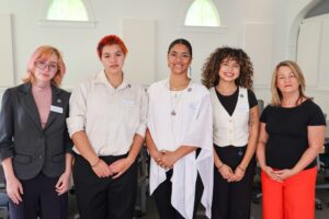 a picture with students standing in room with administration