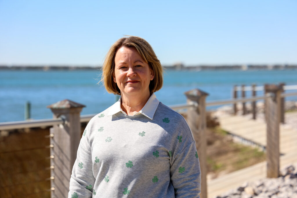 A women standing outside with the ocean in the background