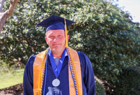 White male student in a cap and gown.