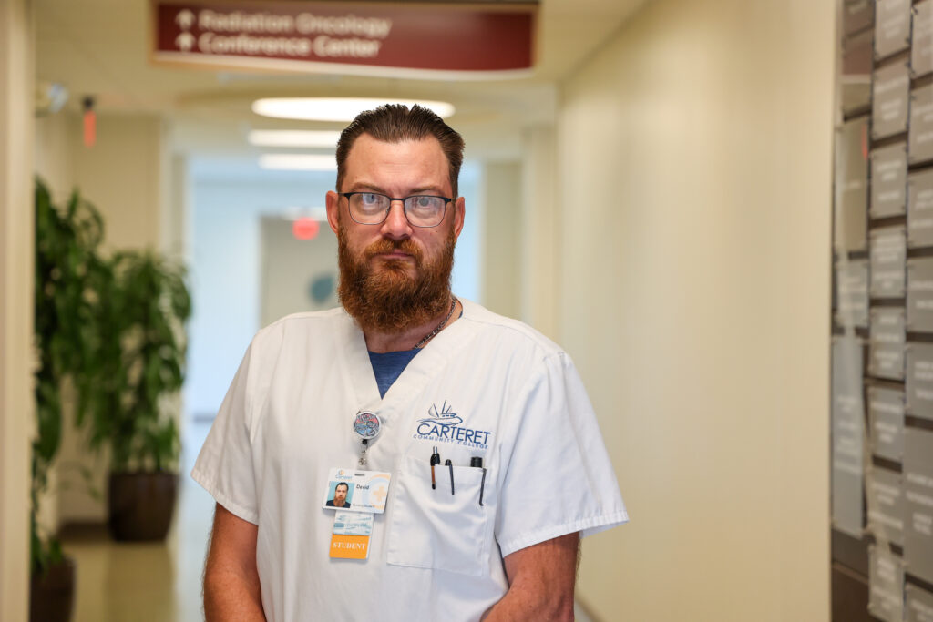 Male student standing in the hospital in his scrubs