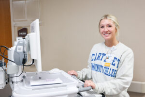 a female student in the hospital working on a medical cart