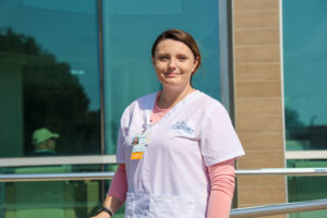 A female standing outside the hospital in scrubs