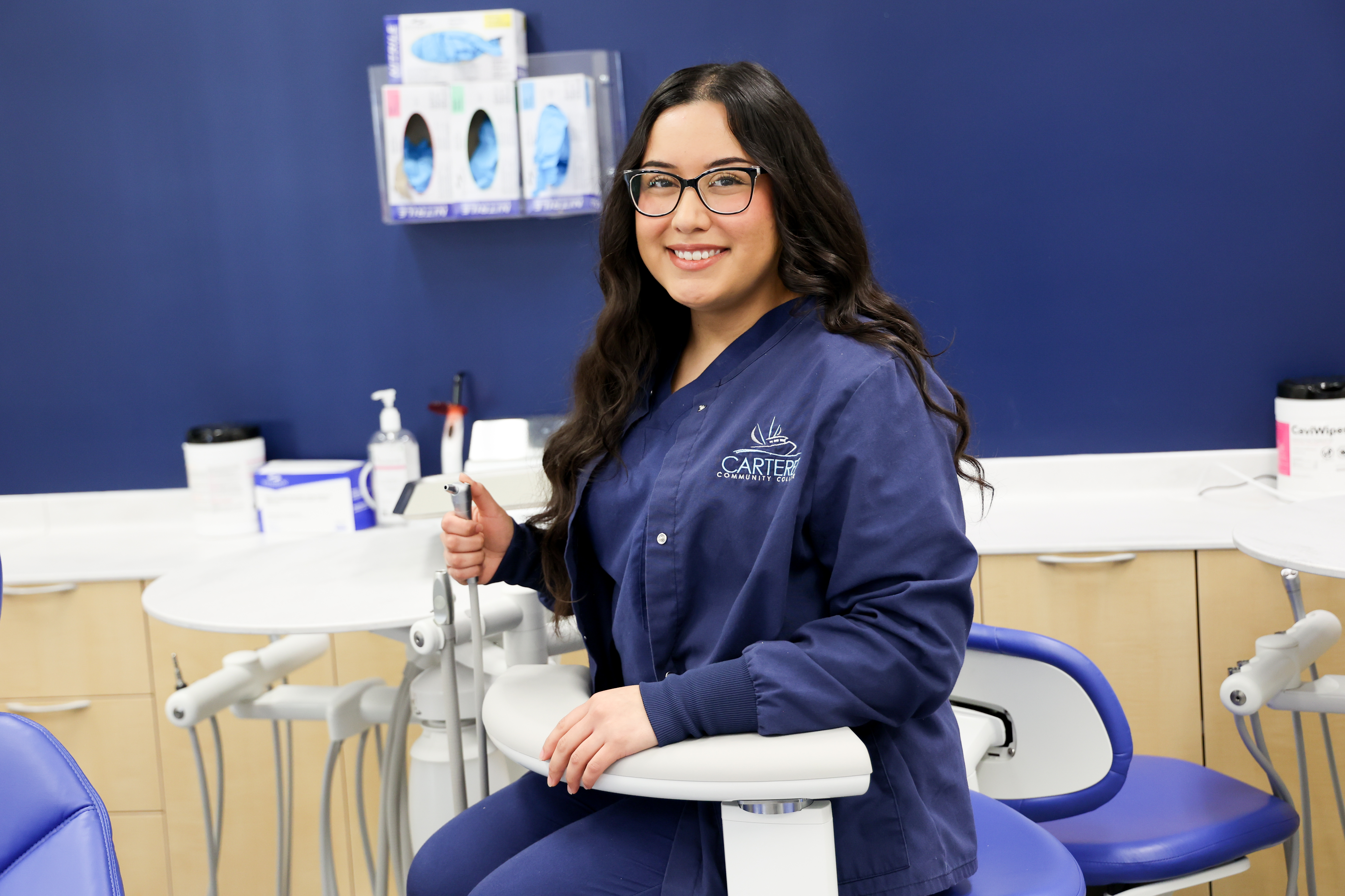 Female student in blue scrubs in dental office