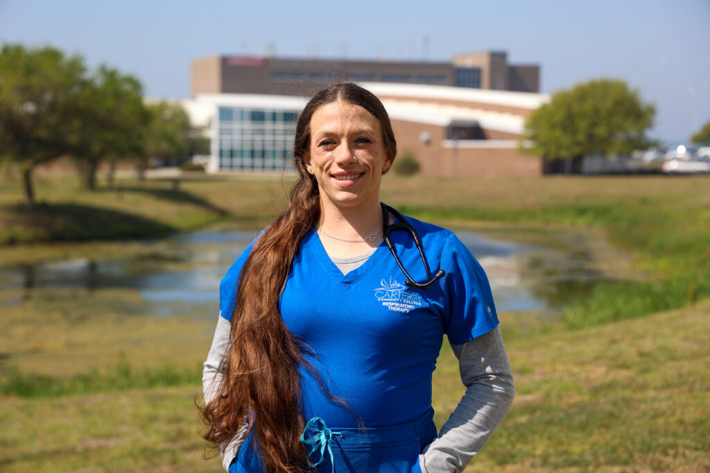 Student standing outside in a blue uniform.